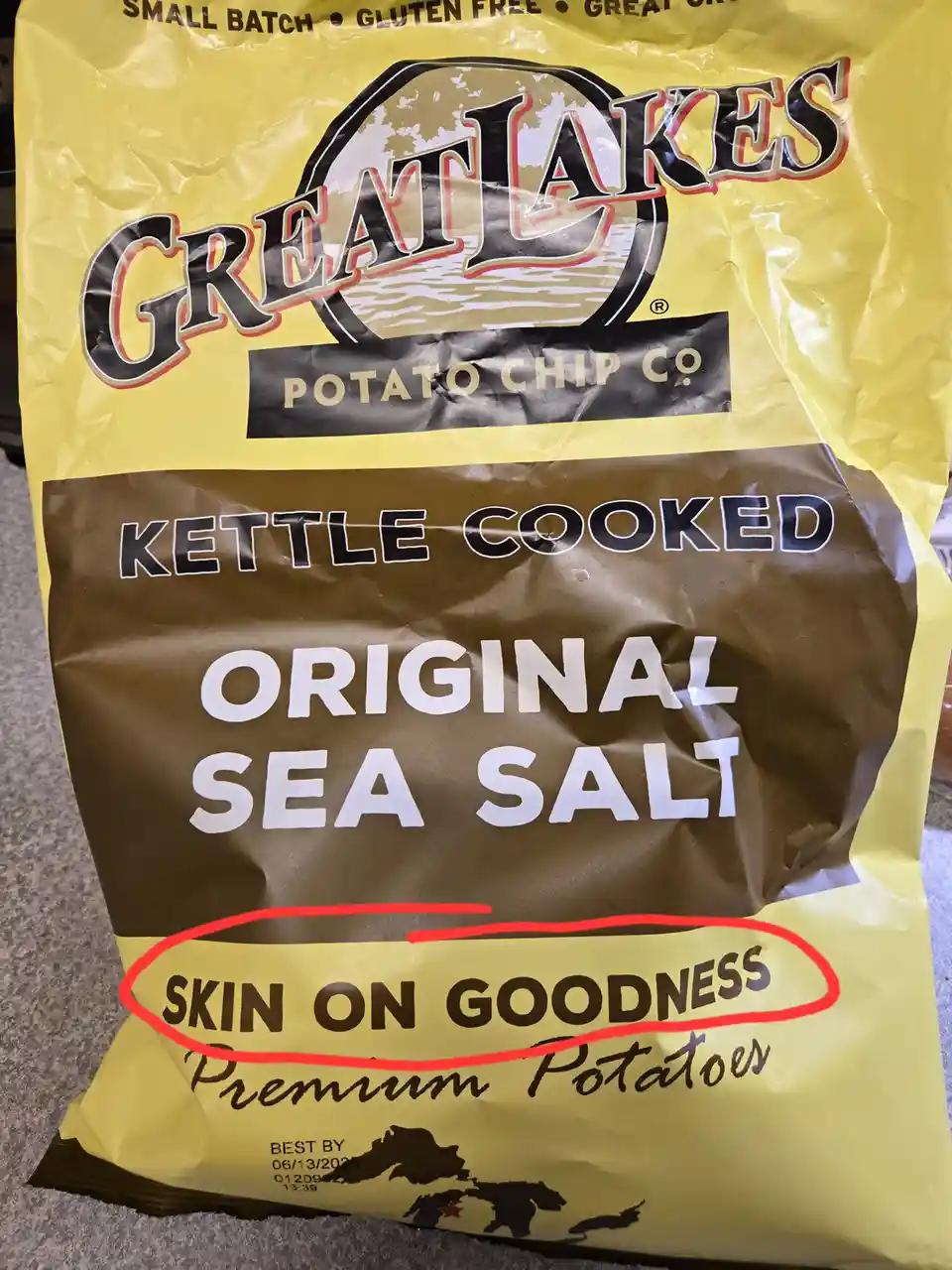 A close-up of a yellow bag of Great Lakes Potato Chip Co. kettle cooked original sea salt chips, with the phrase 'SKIN ON…