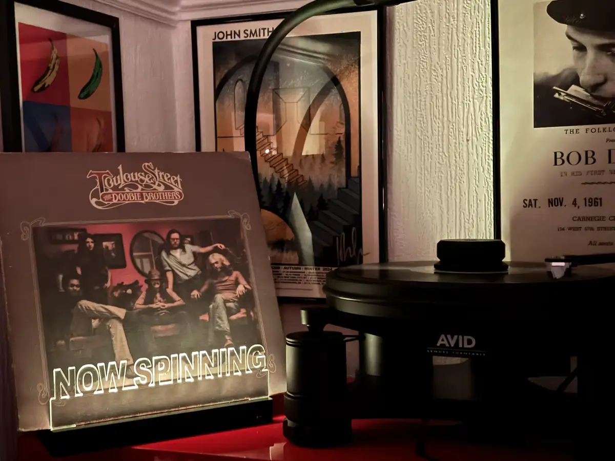 A vinyl record player sits next to a glowing album cover of The Doobie Brothers' 'Toulouse Street', which has the text 'NOW…