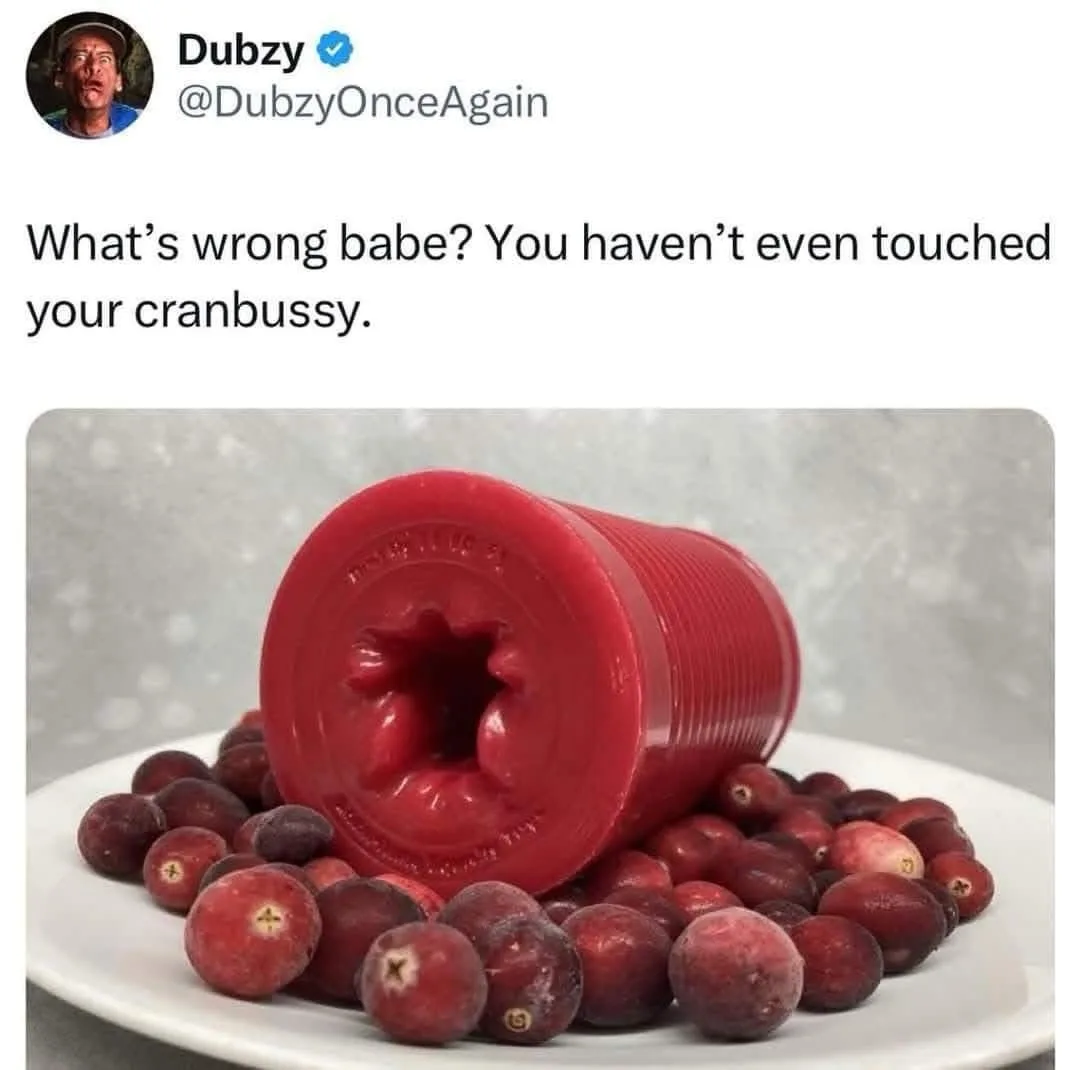 A red, cylindrical, textured object resembling a sex toy lies on its side atop a white plate surrounded by frozen…