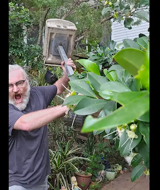 A man with a white beard and glasses is holding an old, dirty-looking electric motor housing upside down, using it as a…