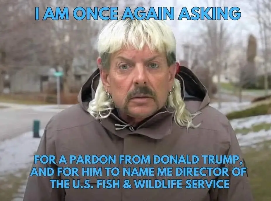 A man with a distinctive blonde mullet, mustache, and earrings, wearing a brown hooded jacket, stares intently at the camera…