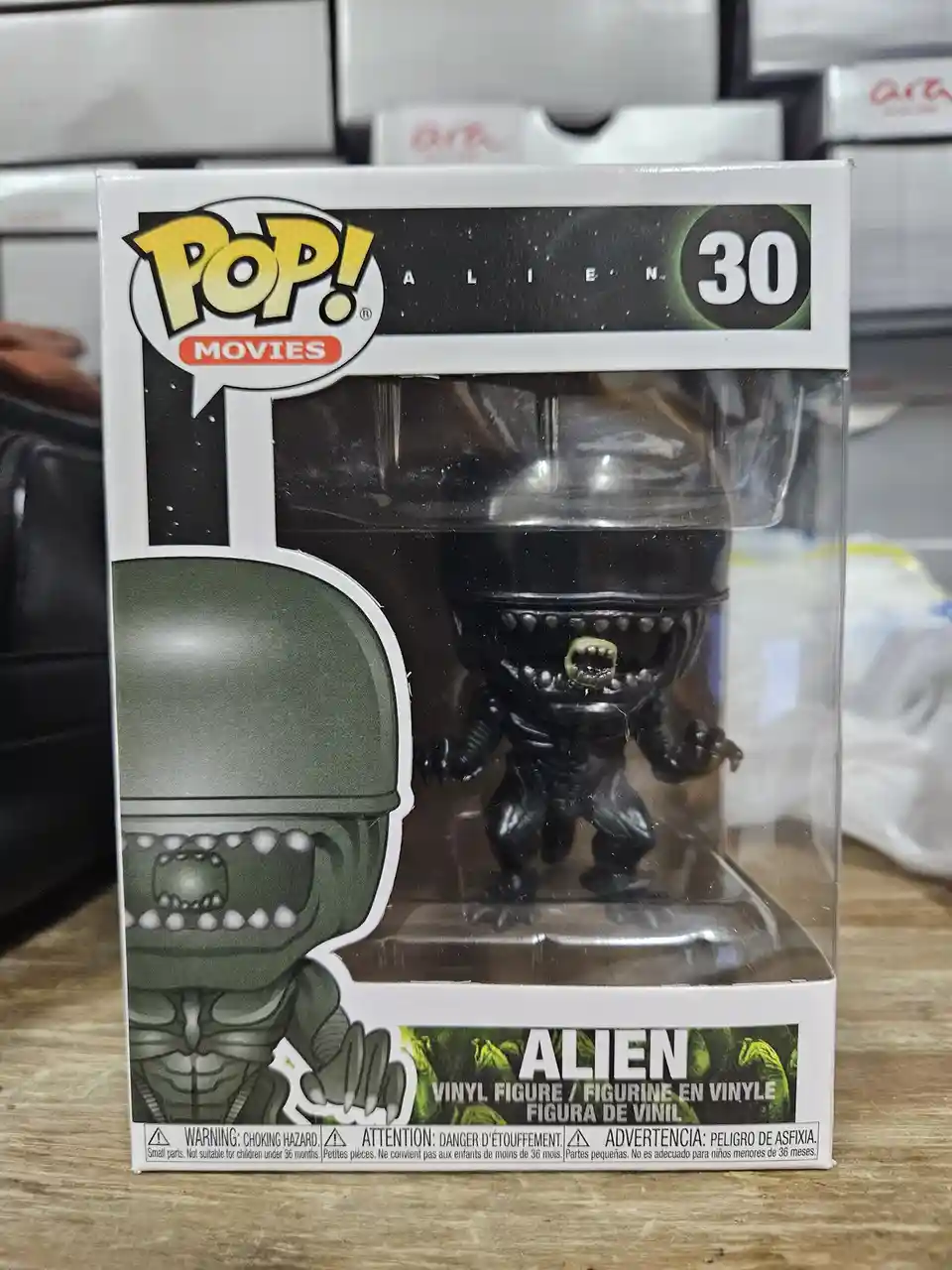 A Funko Pop! Movies vinyl figure of the Alien from the movie franchise, number 30, is shown in its original packaging. The…