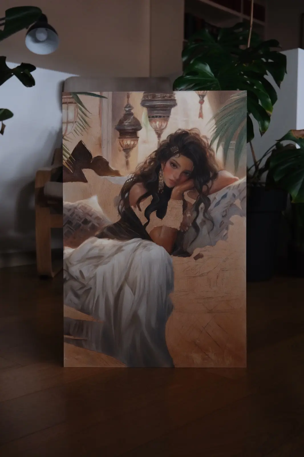 A canvas print of a painting depicting a woman with dark, wavy hair resting her head on her hand while lounging on a bed…