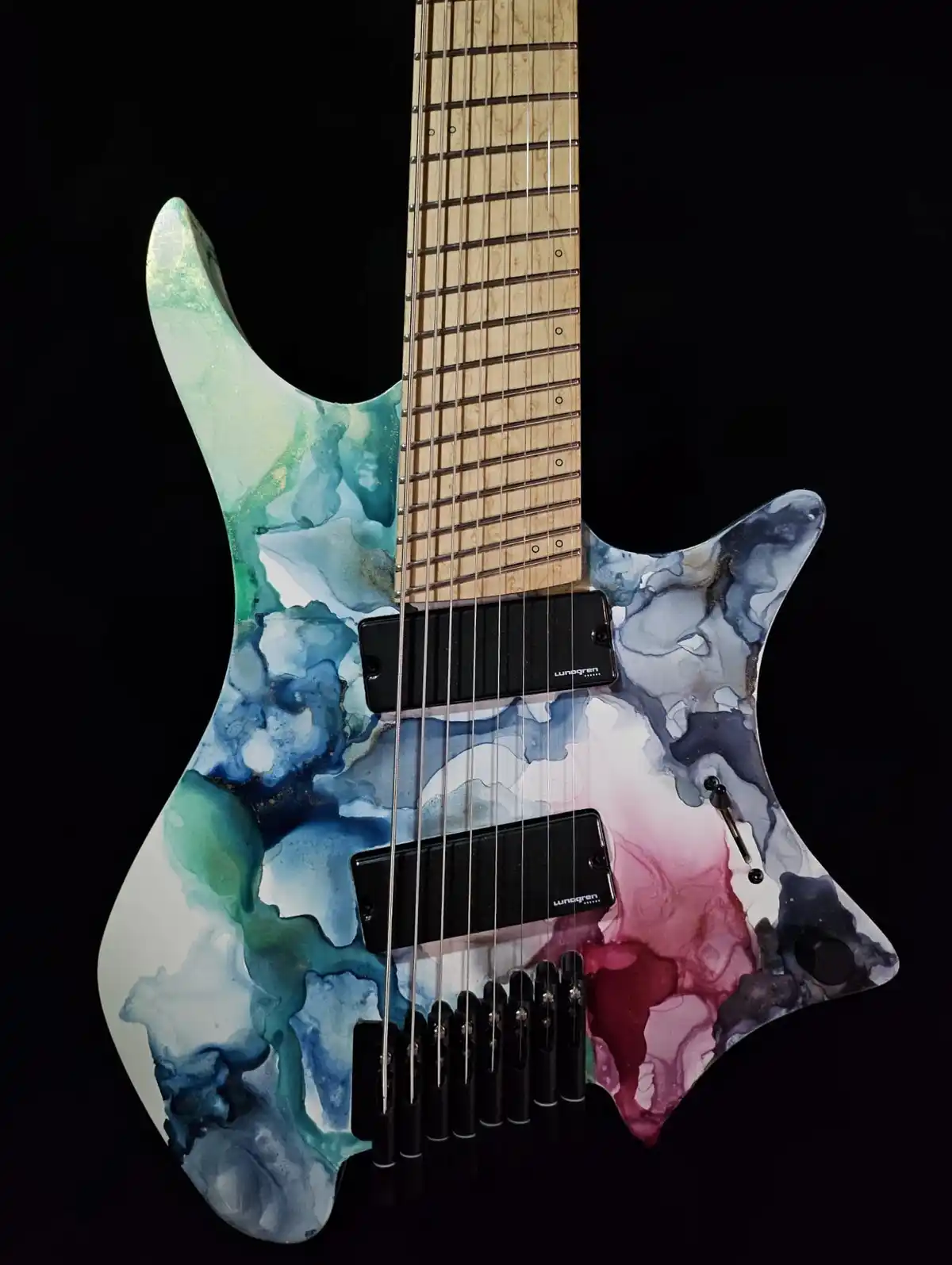 A close-up photo of an electric guitar with a vibrant, abstract watercolor finish blending blues, greens, and pinks on a…