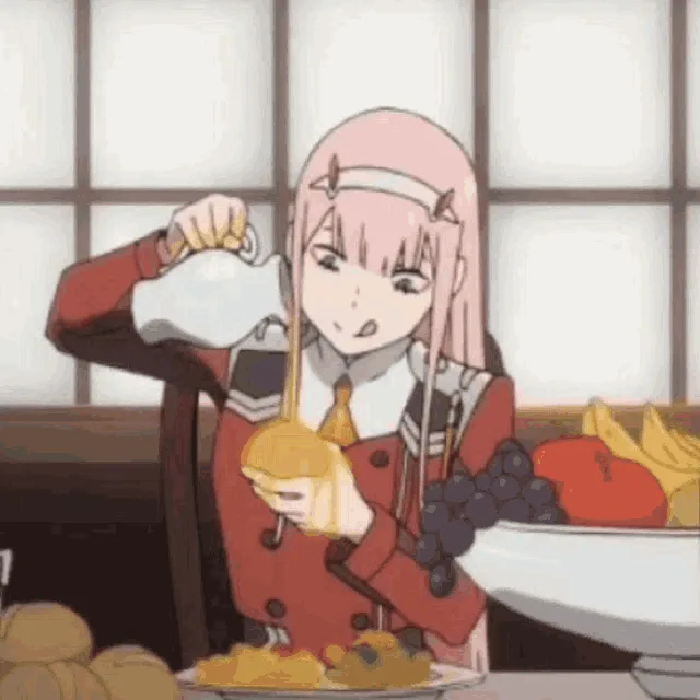 A pink-haired anime girl in a red uniform pours syrup onto a pancake, then eats it with a disgusted expression, as if the…