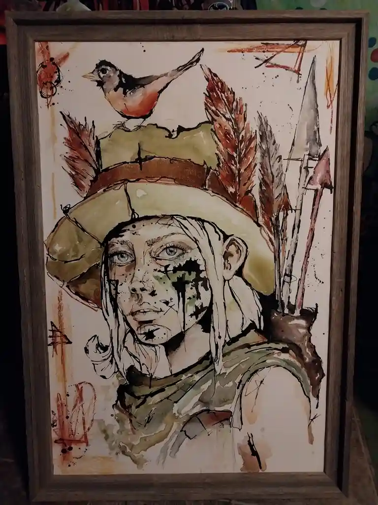 A watercolor painting in a wooden frame depicts a person with light hair and blue eyes, wearing a hat adorned with feathers…