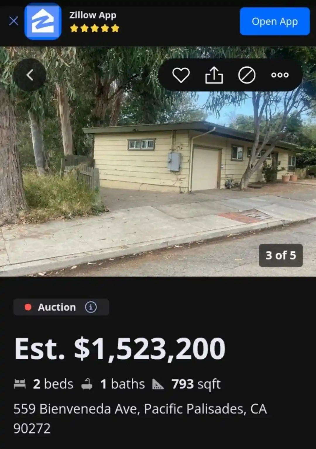 A screenshot from the Zillow app displays a modest, beige, single-story house with a garage, surrounded by trees and…