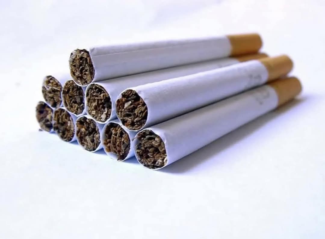 A close-up photograph shows a pyramid of ten cigarettes arranged on a plain white surface, with their cut ends facing the…