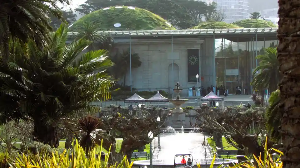 A photo of the California Academy of Sciences in San Francisco, featuring its distinctive green-roofed dome with circular…