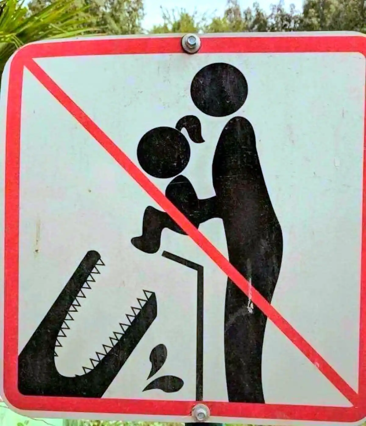 a public warning sign with a red border and diagonal red line over a black pictogram showing an adult holding a child near a…