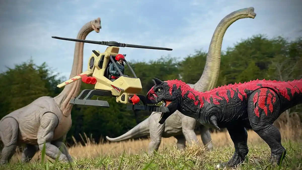 A toy helicopter with a pilot figure is shown hovering and seemingly attacking a black and red toy dinosaur, with two large…