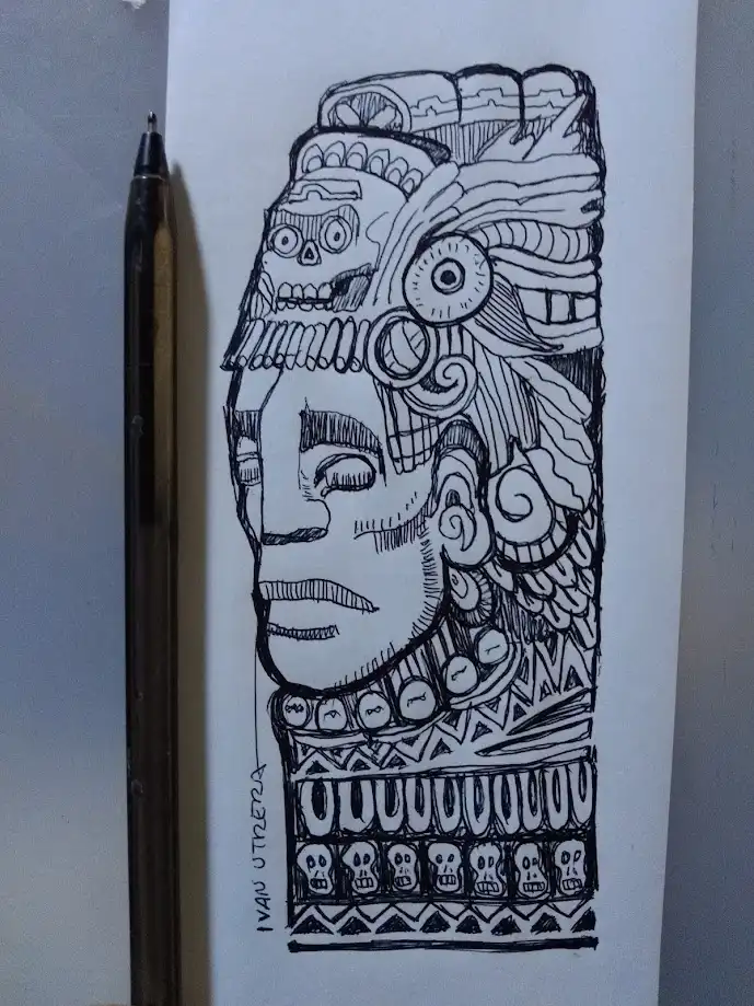A black-and-white ink drawing on paper shows a stylized, ornate human face with elaborate headdress and skull motifs…