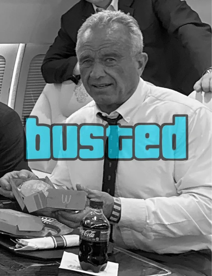 A black-and-white photo shows an older man in a white shirt and tie sitting at a table with a McDonald's burger box and a…