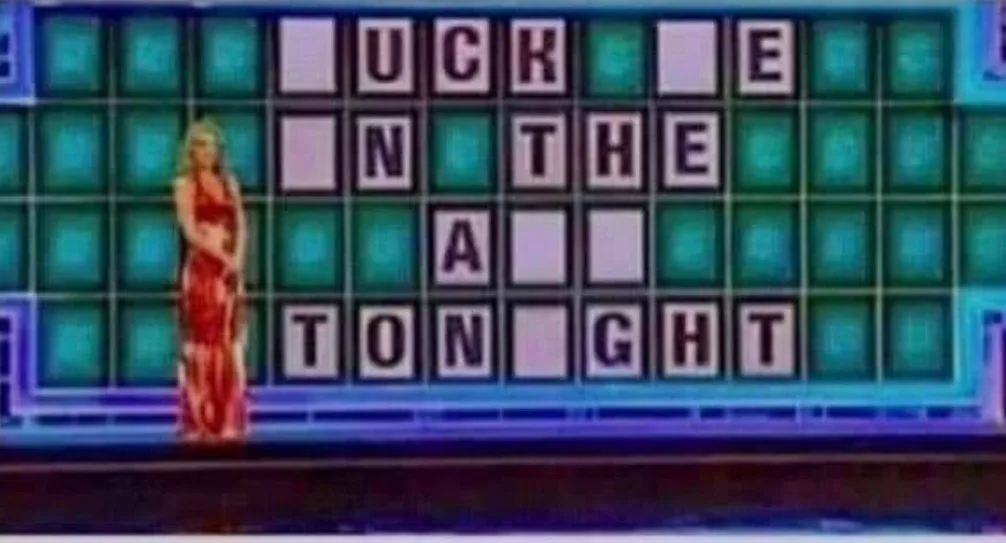 A woman in a red dress stands beside a game show letter board where the visible letters spell 'UCK E N THE A TON GHT'…