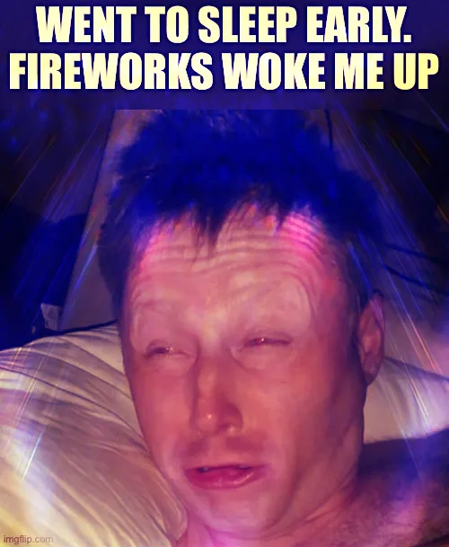 A man is lying in bed with his eyes half-closed, appearing groggy and annoyed, illuminated by colorful, streaky light…