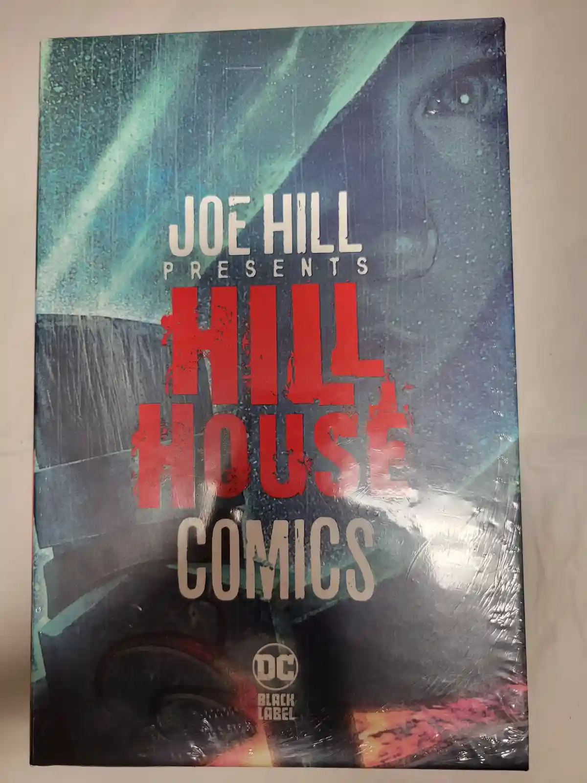 A comic book cover titled 'Joe Hill Presents Hill House Comics' with a dark, rainy, atmospheric illustration featuring a…