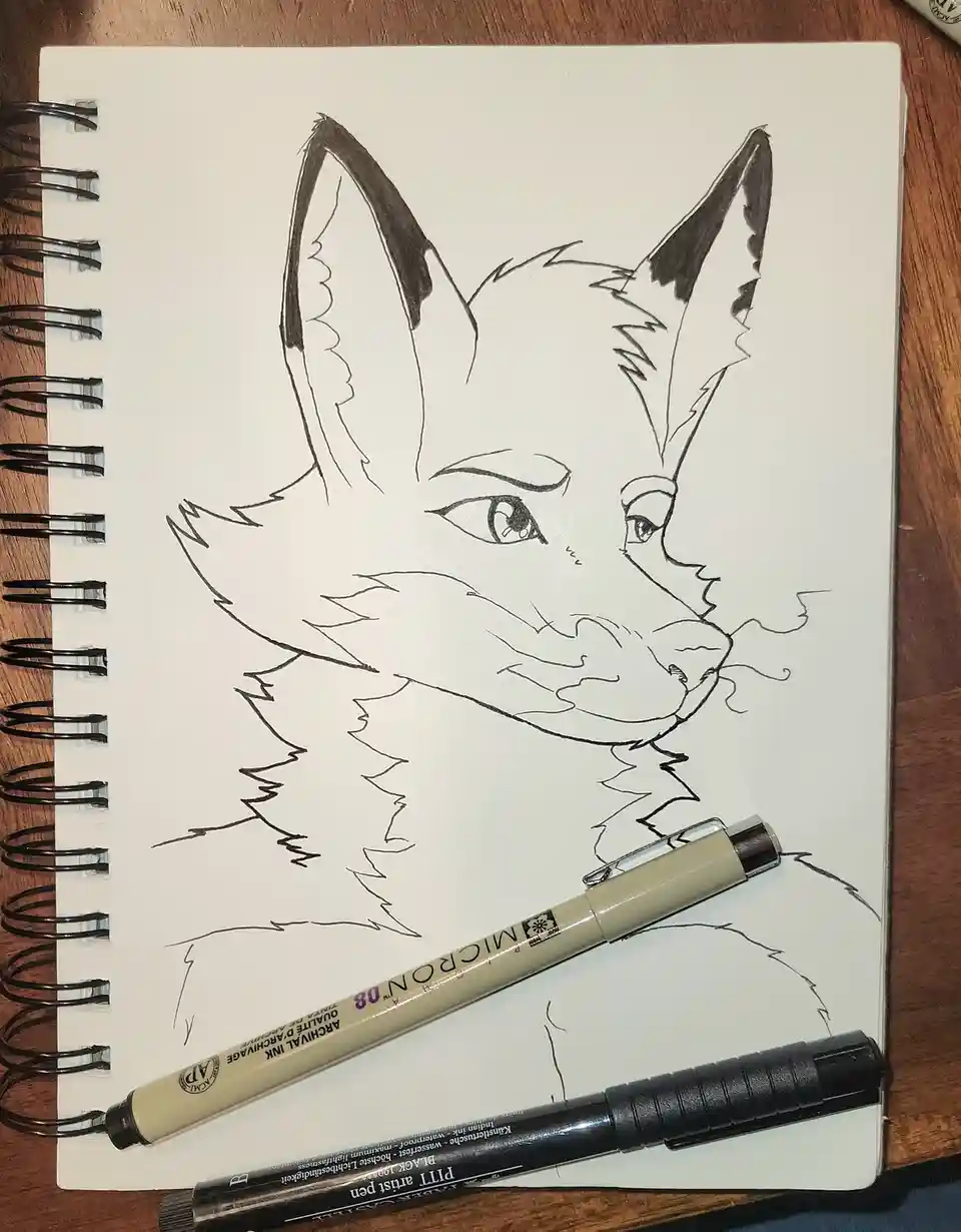 A black-and-white line drawing of a fox's head and shoulders on a spiral-bound sketchbook, with two pens resting on the…