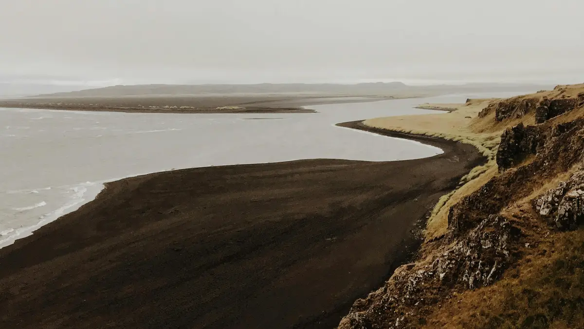 Misty veils cling to the jagged coastline, as if trying to conceal the rugged beauty beneath. Dark grey skies seem to match…