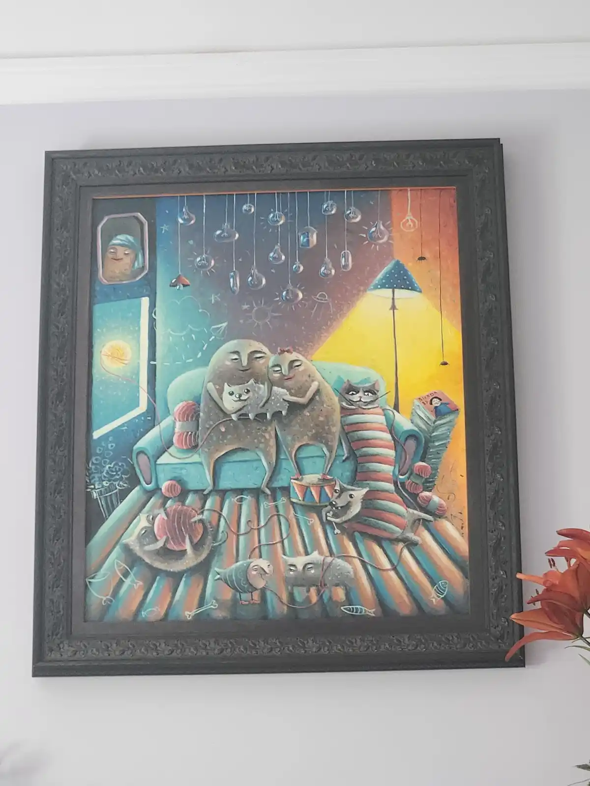 A framed, colorful painting depicts a cozy, surreal scene with two large, round, smiling figures sitting on a couch…
