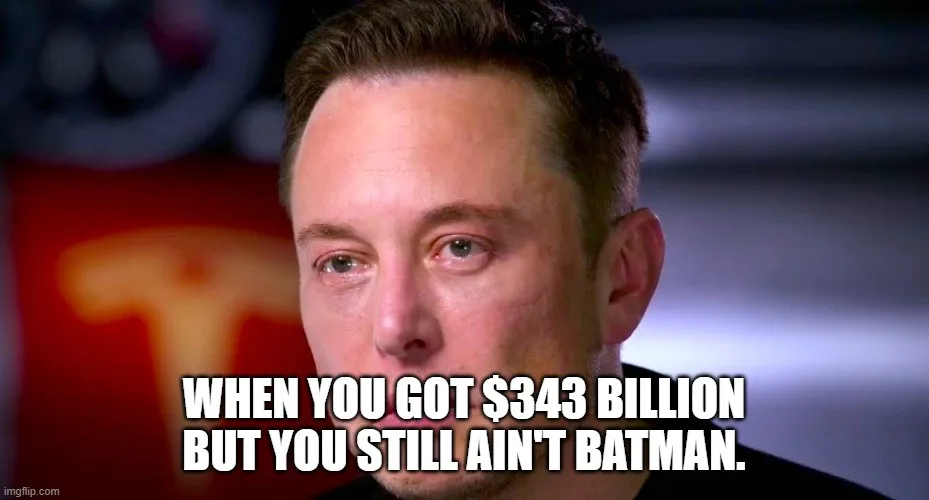 A close-up image of Elon Musk looking slightly weary or resigned, with a blurred background featuring a red object with a…