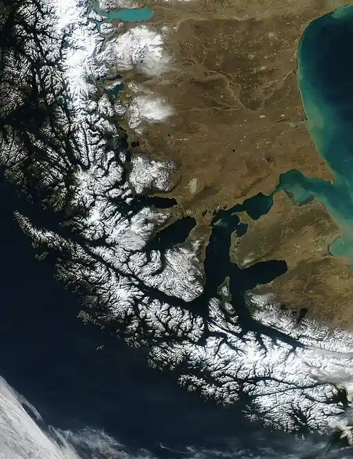 A satellite image shows a vast, snow-covered Arctic region with mountain ranges and sea ice, overlaid with the text 'the…