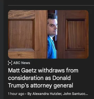 A man in a blue suit peeks cautiously from behind a wooden door, looking over his shoulder with a wary expression. The image…