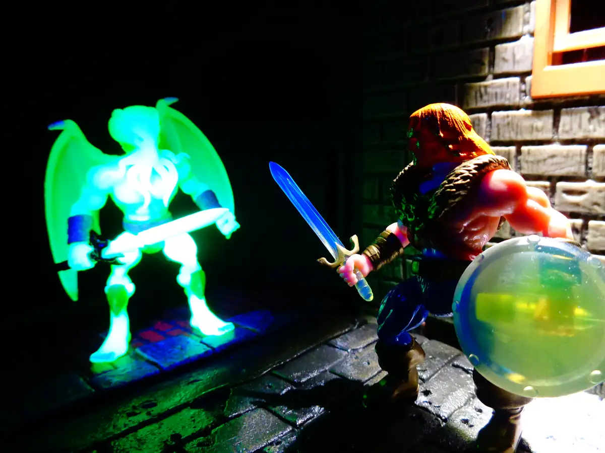 A toy action figure with a sword and shield stands in a dark, brick-walled setting, facing a glowing green, winged…