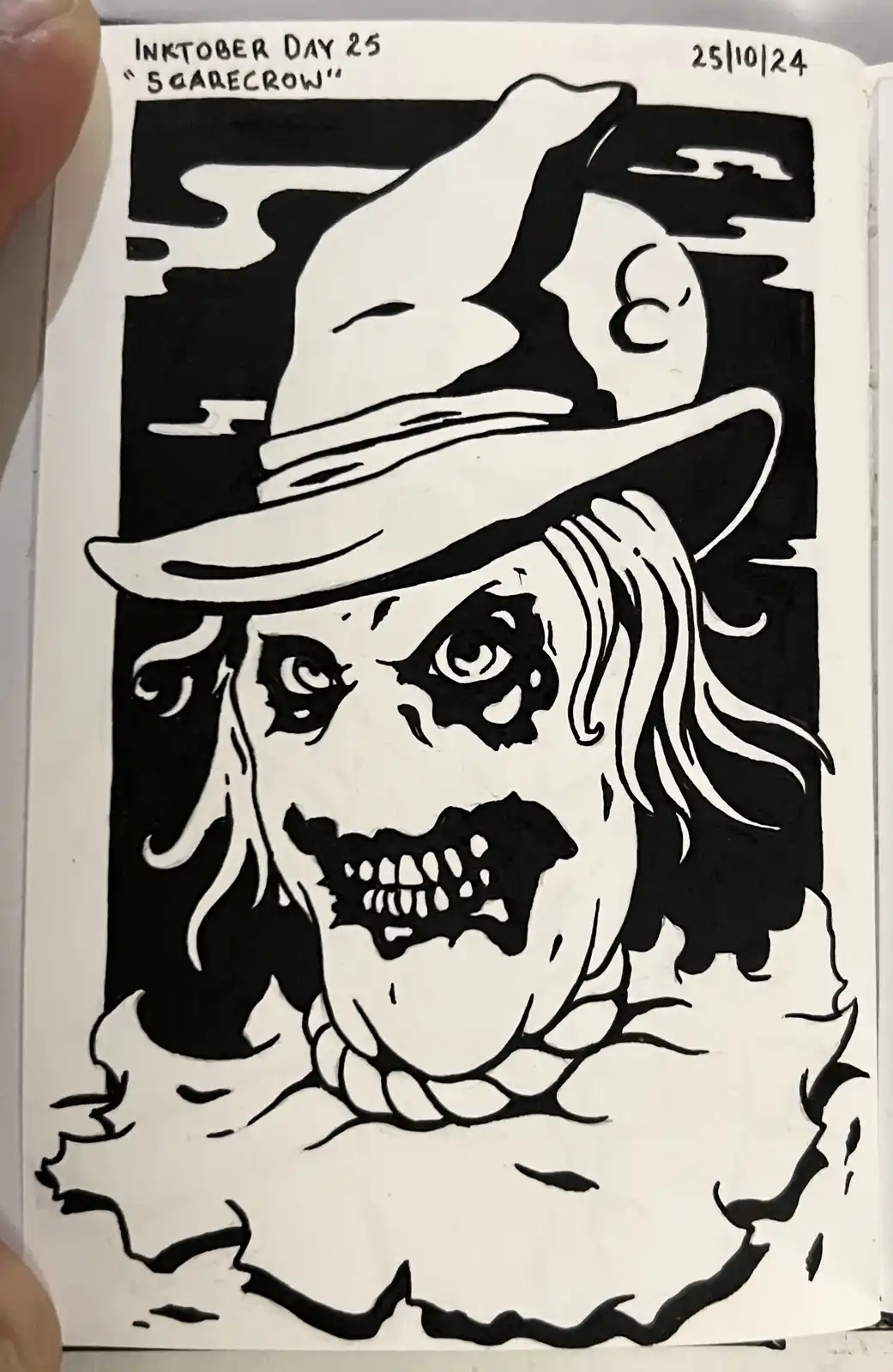 A black-and-white ink drawing depicts a menacing scarecrow with a wide-brimmed hat, wild hair, and a grotesque, screaming…