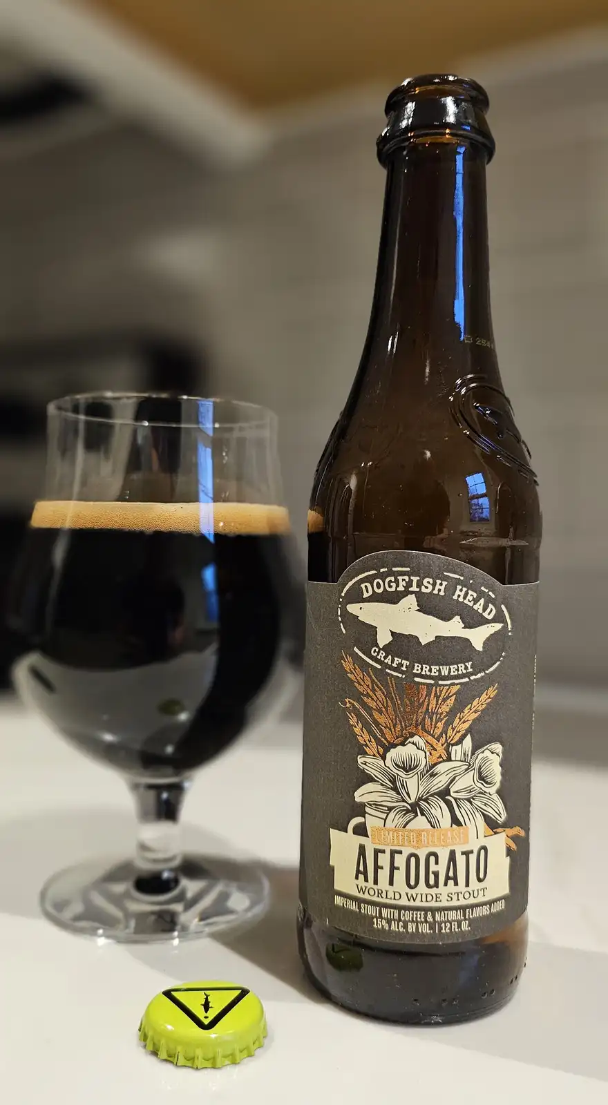A bottle of Dogfish Head Craft Brewery's 'Affogato' Imperial Stout sits next to a glass of the dark beer with a tan head…