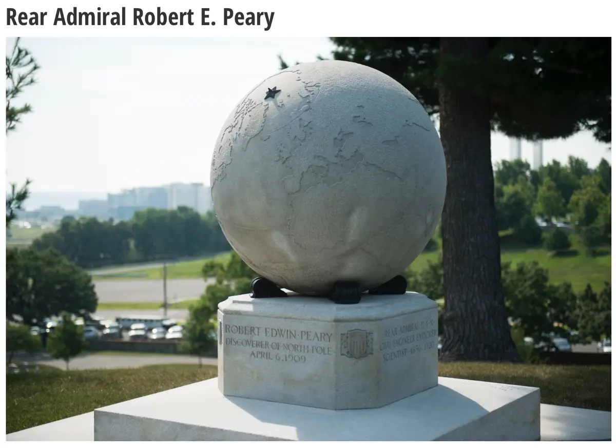 A stone monument features a globe with a star marking the North Pole, mounted on a pedestal inscribed with 'Robert Edwin…