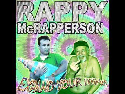 An album cover parody featuring two men against a psychedelic tie-dye background. The man on the left wears a green polo and…