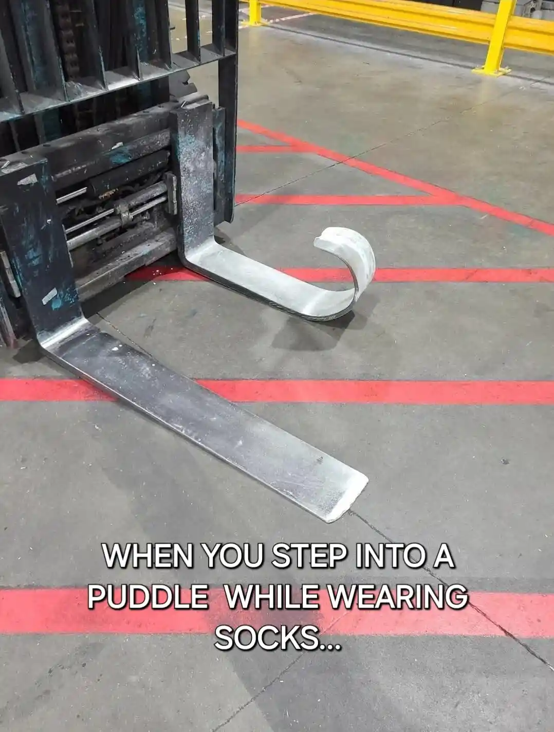 A close-up photo shows the metal forks of a forklift in a warehouse, with one fork visibly bent into a curved, sock-like…