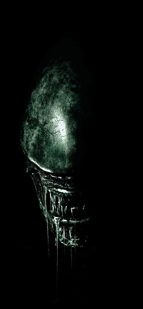 A dark, close-up image of the iconic alien creature from the 'Alien' franchise, its elongated head and jaw dripping with…