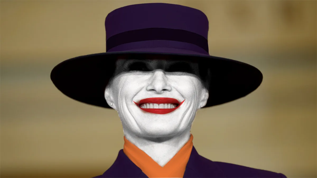 A person wearing a purple top hat and a purple suit with an orange collar, their face is painted white with black eye makeup…
