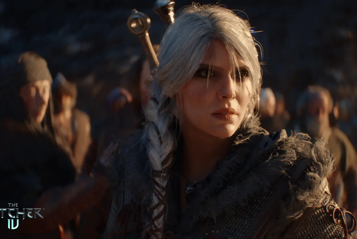 A close-up of a woman with long silver braided hair and a sword hilt visible behind her head, wearing fur-lined armor…