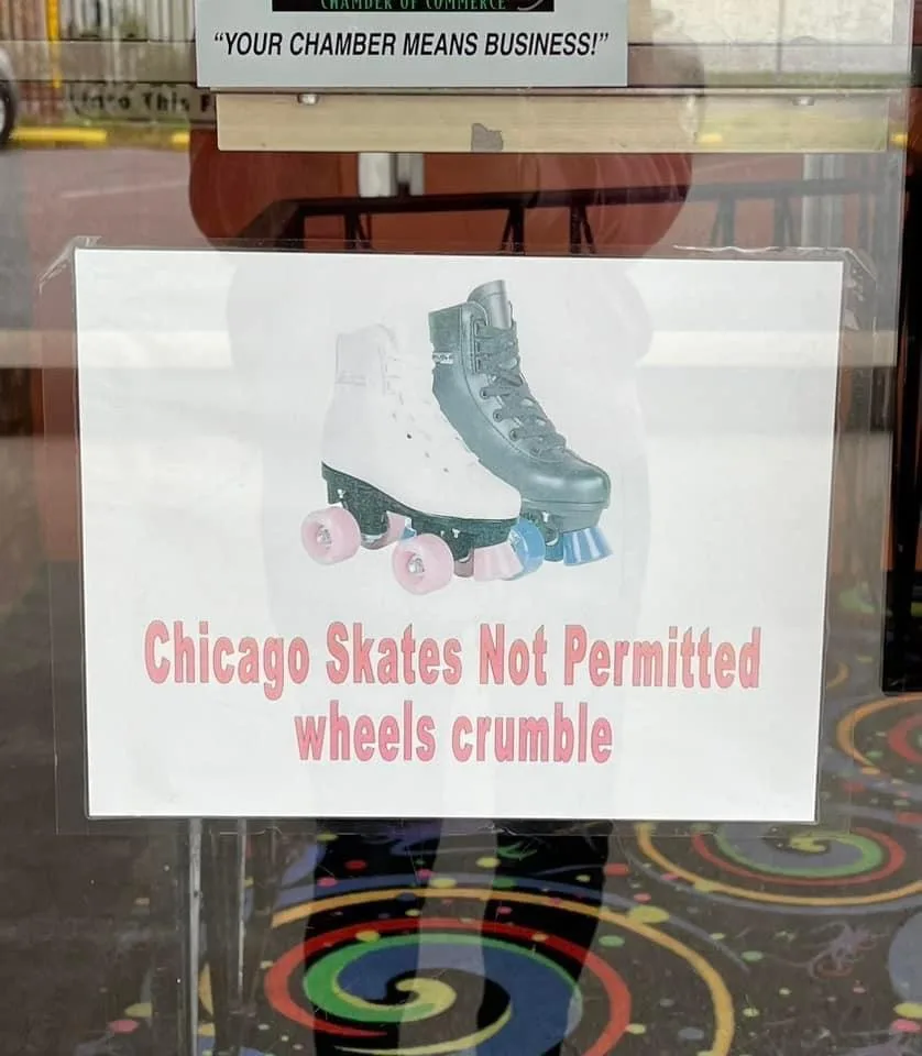 A sign taped to a glass door shows an image of two roller skates, one white and one black, with mismatched pink and blue…