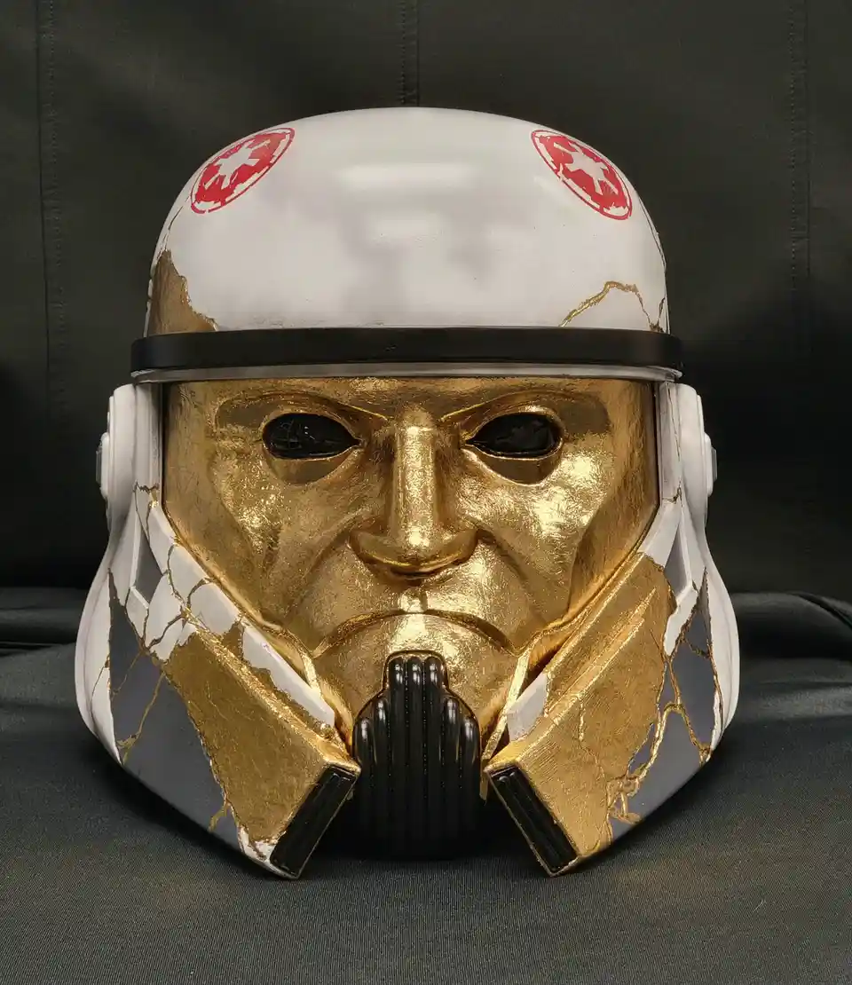 a custom-painted star wars clone trooper helmet is shown with its white and grey sections intentionally cracked and filled…