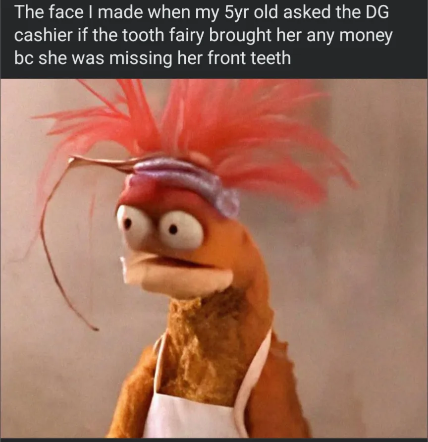 A close-up image of the Muppet character Animal, recognizable by his orange fur, wild red hair, and white apron, with a look…