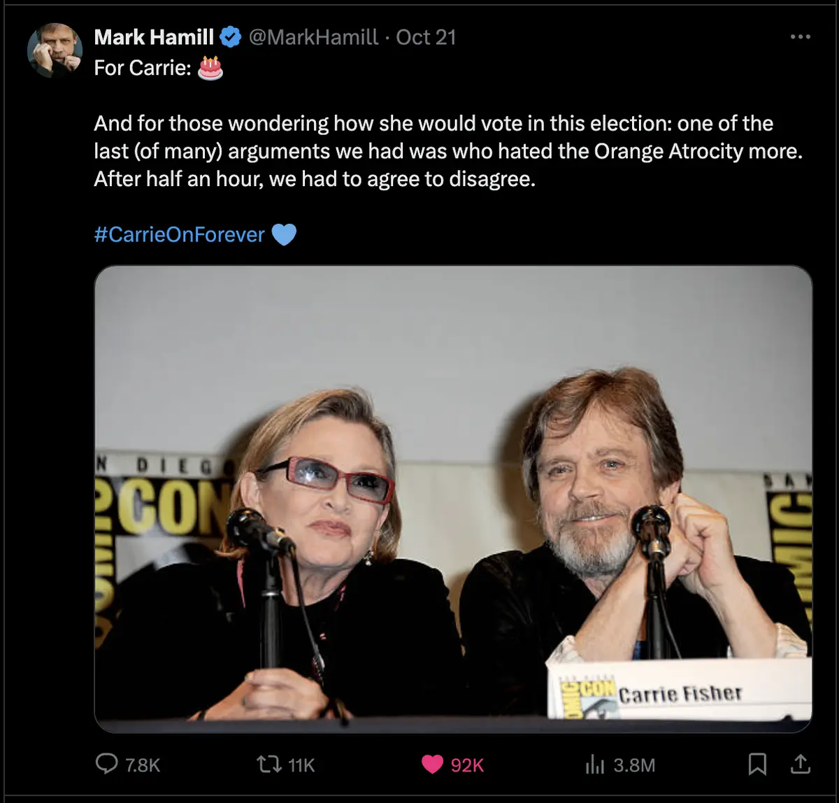 A screenshot of a tweet by Mark Hamill showing a photo of Carrie Fisher and himself at a Comic-Con panel. The text in the…