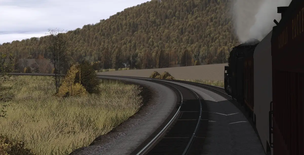 A steam train travels along a curving railway track through a grassy, forested landscape. The train emits smoke from its…