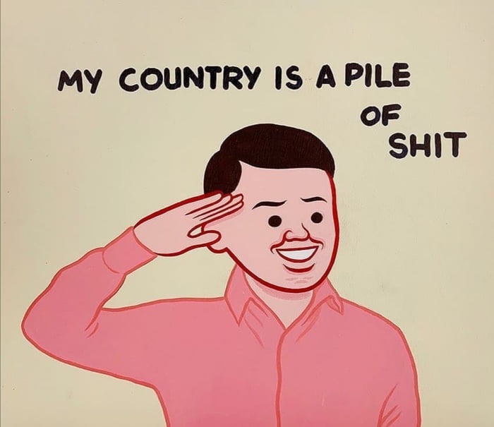 A cartoon man in a pink shirt salutes with a wide, forced smile while the text above him reads 'MY COUNTRY IS A PILE OF…