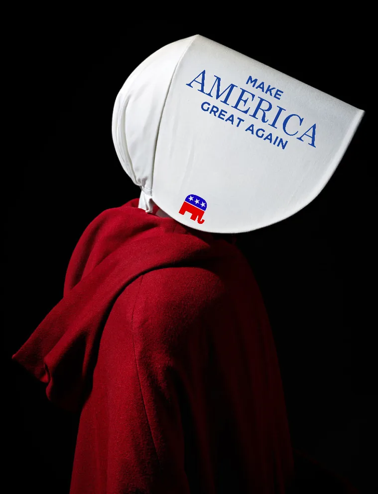 A person in a red hooded robe and a white bonnet, seen from the side against a black background. The bonnet has the text…