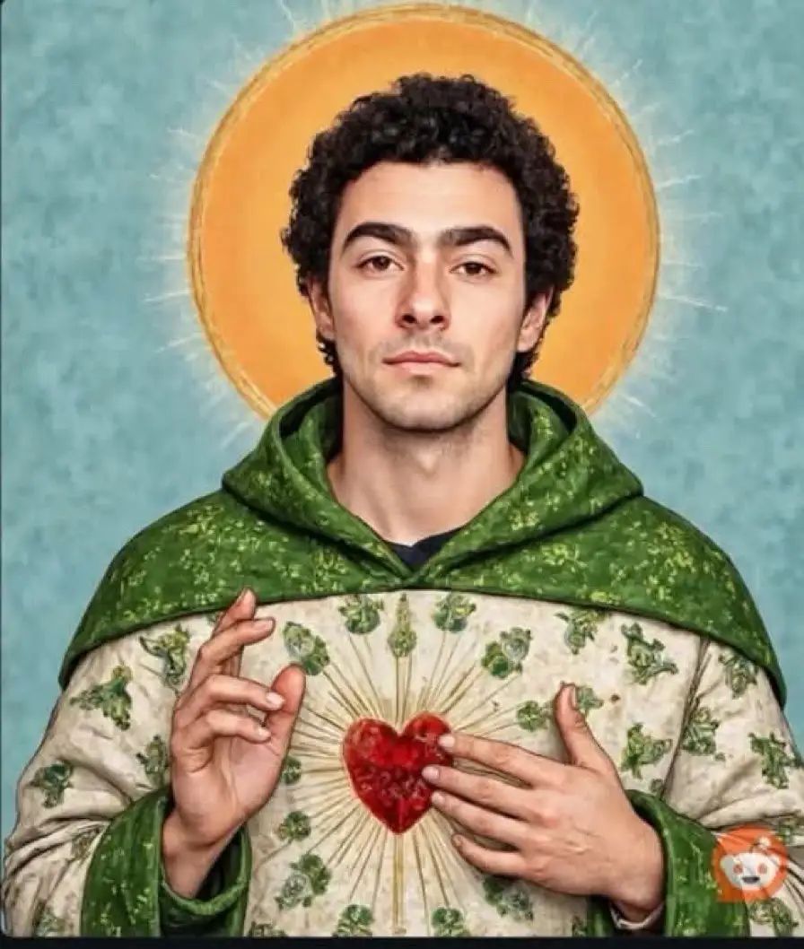 A man with curly dark hair, wearing a green hooded robe over a white tunic with shamrock patterns, holds a glowing red heart…