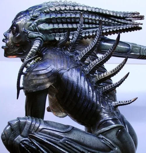 A highly detailed, metallic statue of the Alien creature from the 'Alien' franchise, shown in a crouching pose with its…