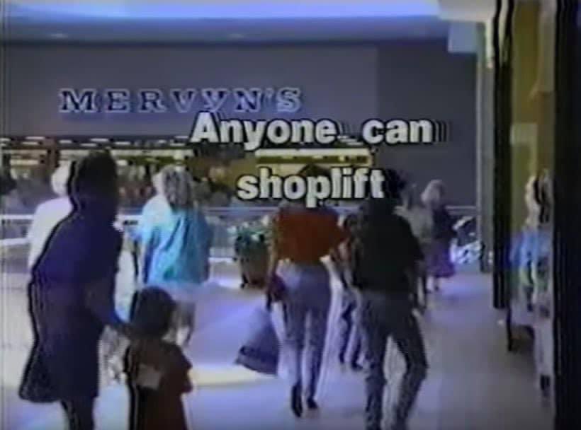 A grainy, low-resolution security camera-style image from inside a Mervyn's department store, showing several shoppers…