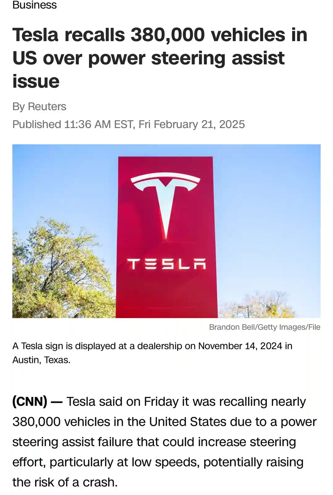 A screenshot of a Reuters news article from February 21, 2025, featuring a large red Tesla sign against a blue sky with…