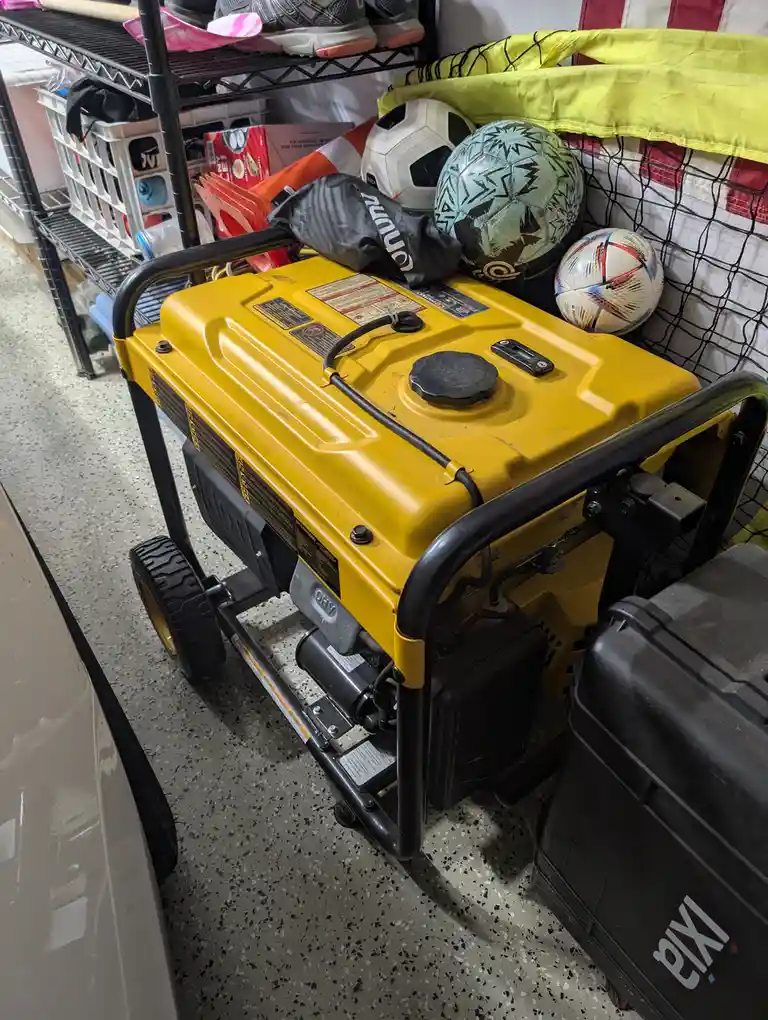 A yellow portable generator sits in a garage, with three soccer balls resting on top of it. The generator is surrounded by…