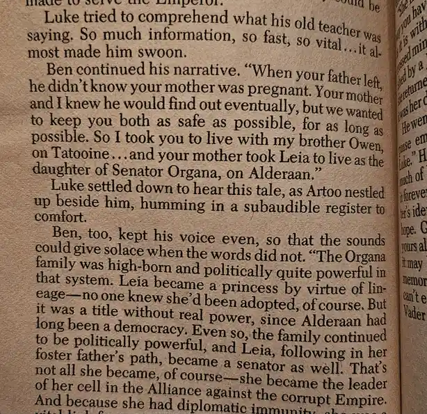 A close-up of a printed book page from a Star Wars novel, showing text about Luke Skywalker's backstory. The visible…