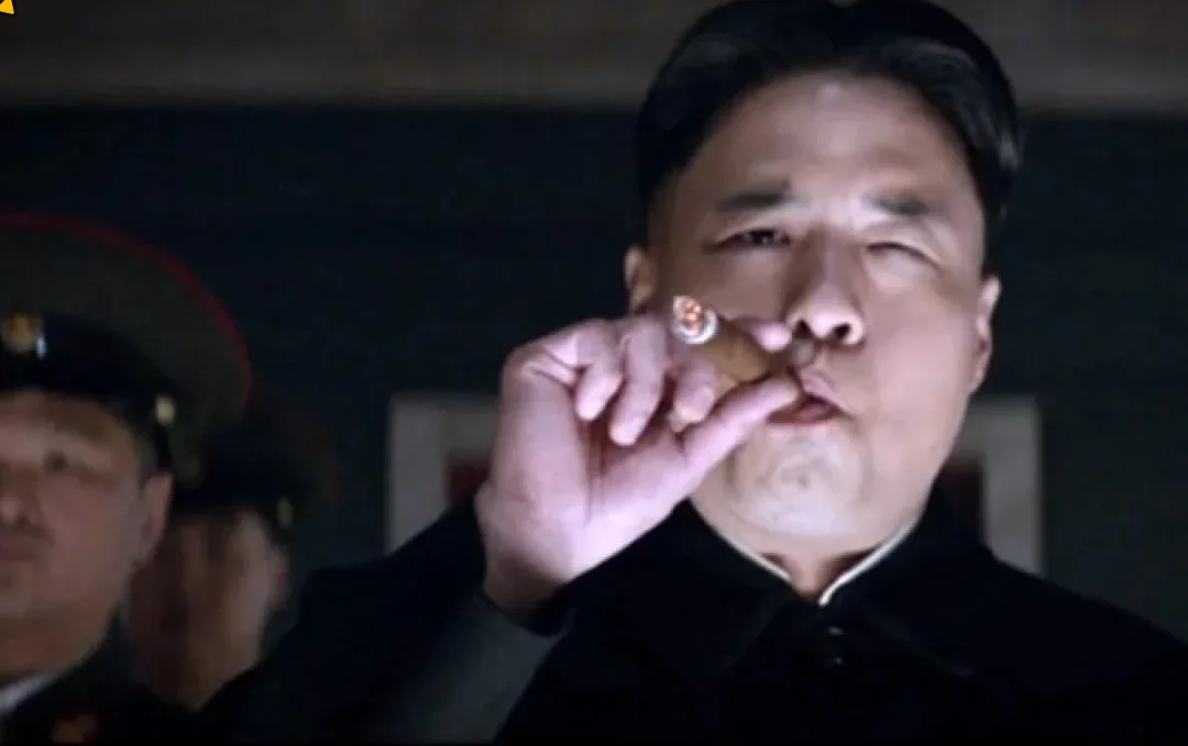 a man in a dark suit holds a cigar near his mouth, winking with one eye while looking smug. Another man in a military-style…