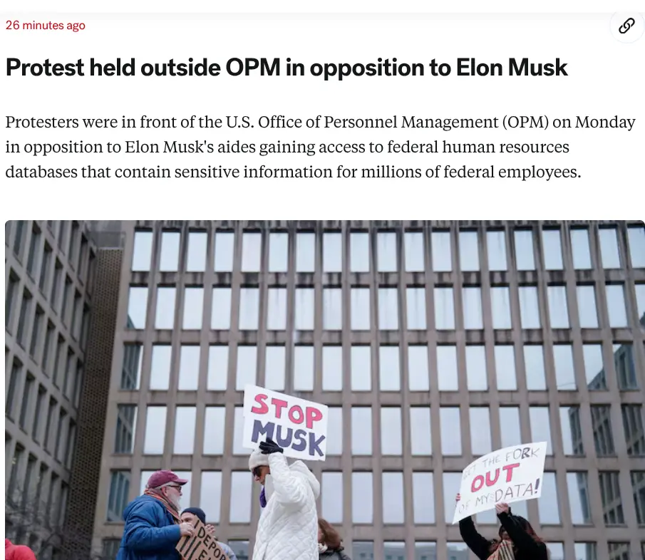 Protesters stand outside a large office building holding signs that read 'STOP MUSK' and 'GET THE FORK OUT OF MY DATA!' The…